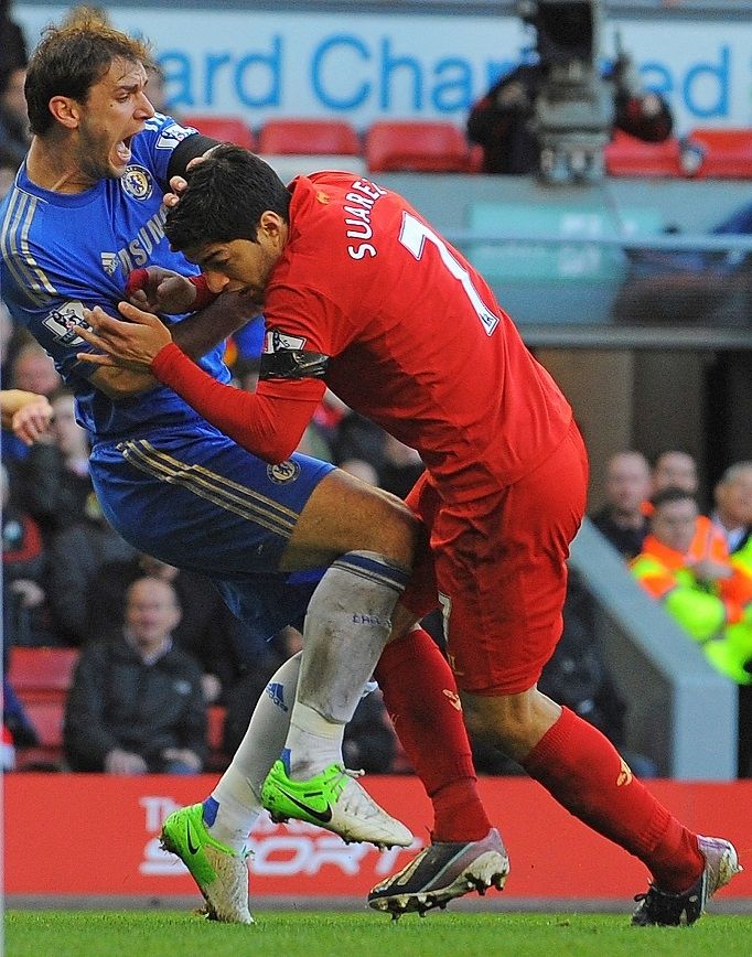 Luis Suarez menggigit tangan Branislav Ivanovic di laga Liverpool vs Chelsea yang digelar di Anfield pada 2013. [AFP]