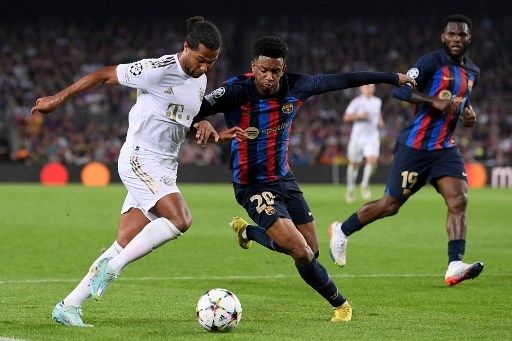 Pemain Barcelona Alejandro Balde berduel dengan pemain Bayern Munich Serge Gnabry dalam pertandingan Grup C Liga Champions di Camp Nou pada 26 Oktober 2022. [AFP]