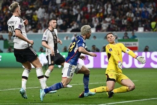 Pemain Jepang Takuma Asano menjebol gawang Jerman yang dikawal Manuel Neuer dalam pertandingan Grup E Piala Dunia 2022 di Khalifa International Stadium, Rabu (23/11/2022). [AFP]