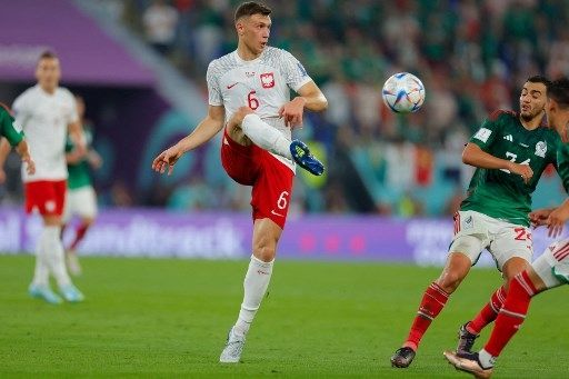 Pemain Polandia Krystian Bielik berebut bola dengan pemain meksiko di matchday pertama Piala Dunia 2022 yang digelar di Stadion 974, Doha, Qatar, 22 November 2022. [AFP]