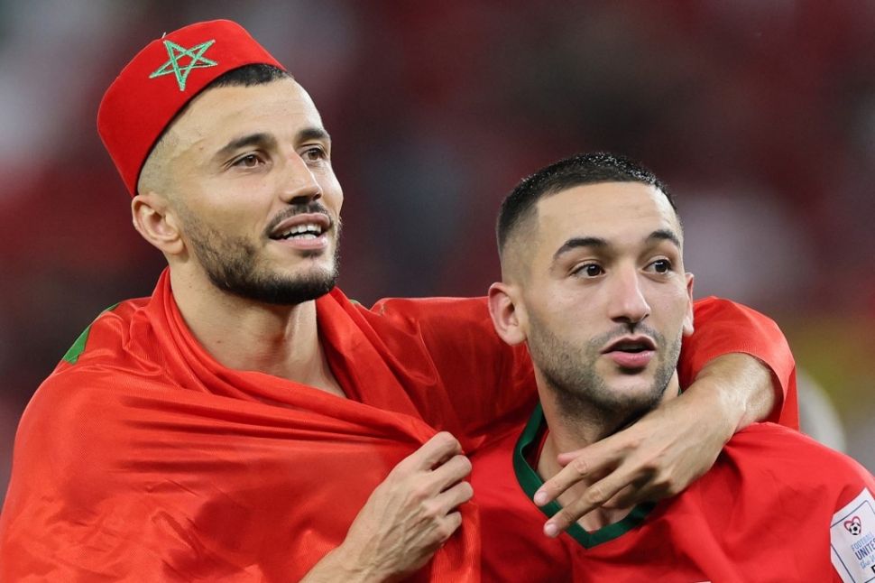 Winger Timnas Maroko, Hakim Ziyech (kanan) dan kapten Romain Saiss di Piala Dunia 2022. [KARIM JAAFAR / AFP]