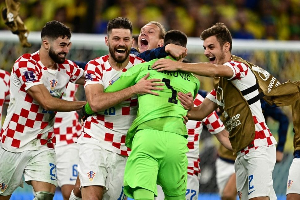 Kiper Timnas Kroasia, Dominik Livakovic (kedua kanan) melakukan selebrasi bersama rekan-rekan setimnya usai adu penalti laga perempat final Piala Dunia 2022 kontra Brasil di Stadion Education City, Al Rayyan, Qatar, Sabtu (10/12/2022) dini hari WIB.[GABRIEL BOUYS / AFP]