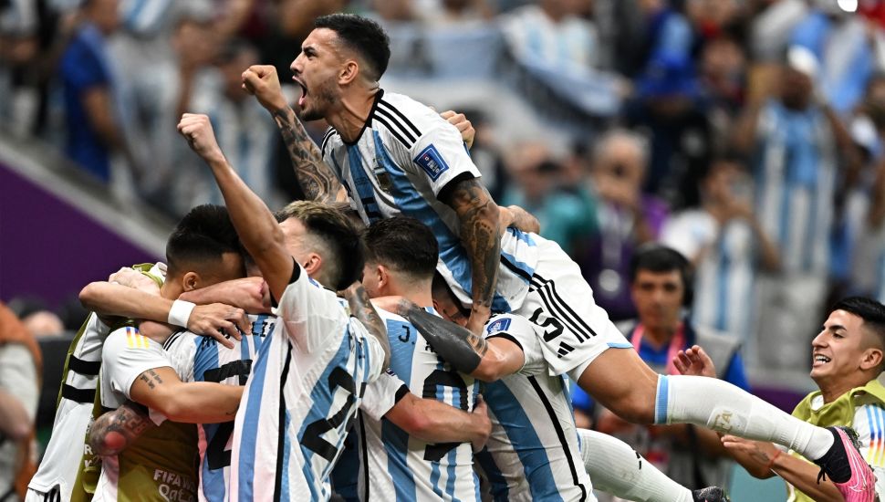 Gelandang Argentina Leandro Paredes melompati rekan satu timnya saat mereka selebrasi ketika pemain depan Argentina Lionel Messi mencetak gol saat pertandingan sepak bola perempat final Piala Dunia 2022 antara Belanda dan Argentina di Stadion Lusail, utara Doha, Qatar, Jumat (9/12/2022). [MANAN VATSYAYANA/AFP]