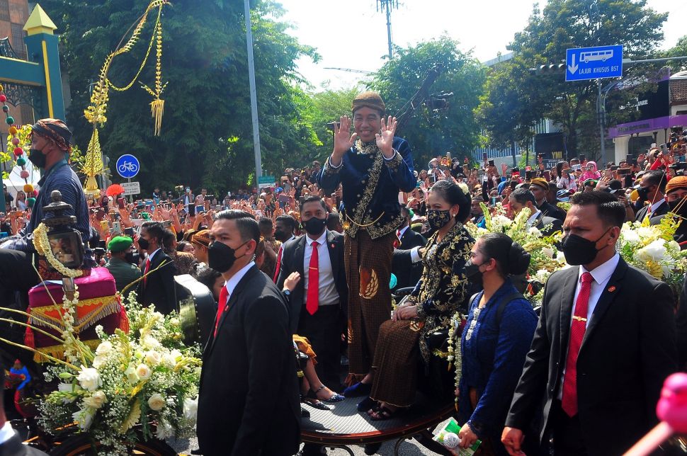 Presiden Joko Widodo (ketiga kanan) menyambut warga saat menaiki kereta dalam mengikuti prosesi kirab Ngunduh Mantu di jalan Selamet Riyadi, Solo, Jawa Tengah, Minggu (11/12/2022). [ANTARA FOTO/Yusuf Nugroho].