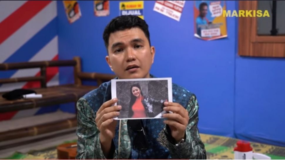 Aldi Taher memegang foto Dewi Perssik sebelum mengantongi ke dalam saku celananya (YouTube/Opra Entertainment)