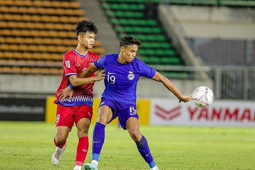 Pemain Singapura dan Laos berebut bola dalam pertandingan Piala AFF 2022 Grup B yang berlangsung di Stadion Nasional KM16, Selasa (27/12/2022). [Foto: affmitshubishielectriccup]