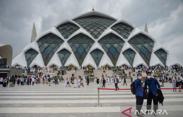 Warga berfoto di pelataran Masjid Raya Al Jabbar di Gedebage, Bandung, Jawa Barat, seusai acara peresmian masjid pada Jumat (30/12/2022). [ANTARA FOTO/Raisan Al Farisi/aww]