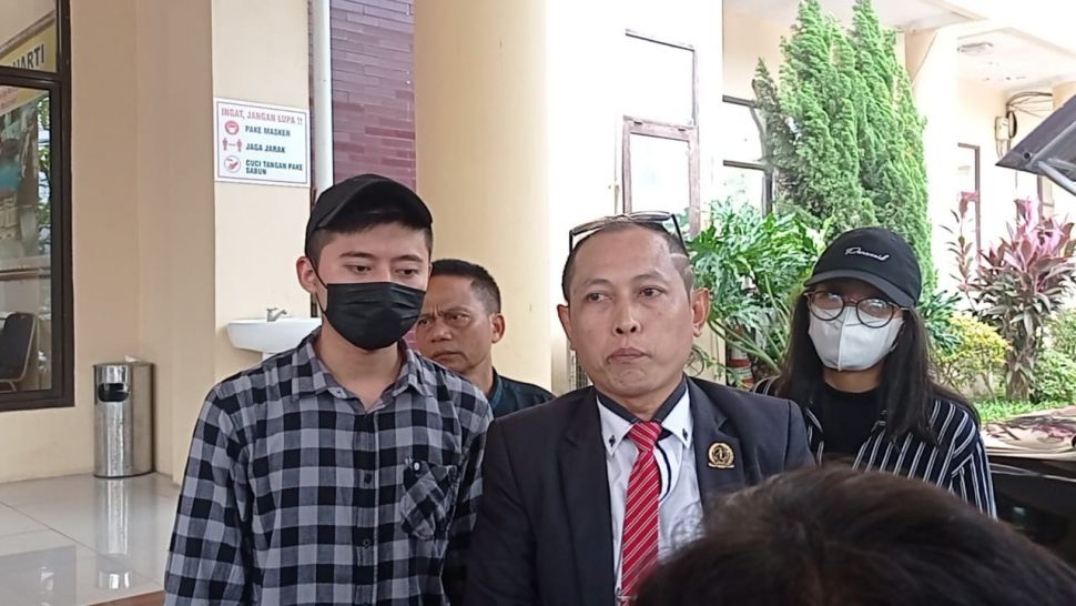 Rozy Zay Hakiki (kemeja kotak-kotak) didampingi pengacara mendatangi Polda Banten, Kamis (5/1/2023) untuk melaporkan mantan istri, Norma Risma. [Suara.com/Rena Pangesti]