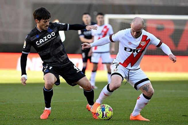 Pemain Real Sociedad David Silva berebut bola dengan pemain Rayo Vallecano dalam pertandingan La Liga di Estadio Camp de Futbol de Vallecas, Sabtu (21/1/2023). [AFP]