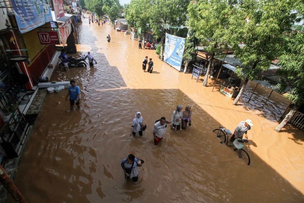 Warga melintasi banjir di Desa Kedawung, Grati, Pasuruan, Jawa Timur, Sabtu (11/2/2023). ANTARA FOTO/Umarul Faruq].