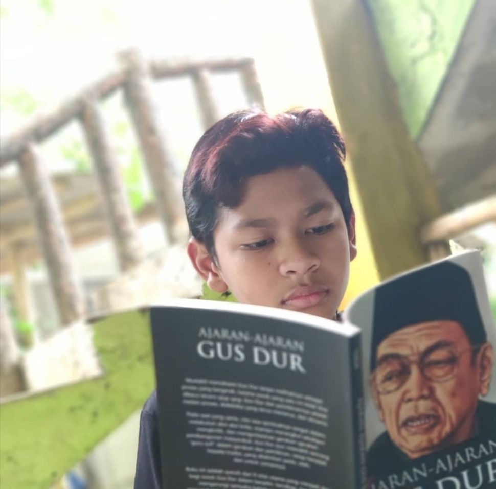 Putri sulung mendingan Gus Dur dan Sinta Nuriyah, Alissa Wahid mengunggah foto David kecil tengah membaca buku Gus Dur. (Twitter @/AlissaWahid)