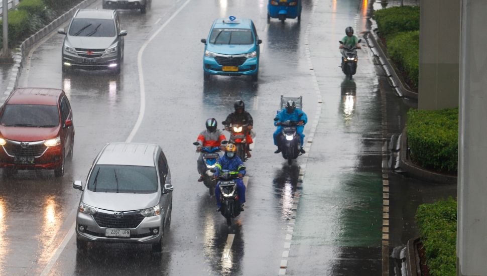 Pengendara motor nelintas saat hujan lebat di Jalan Gatot Subroto, Jakarta, Kamis (3/3/2023). [Suara.com/Alfian Winanto]