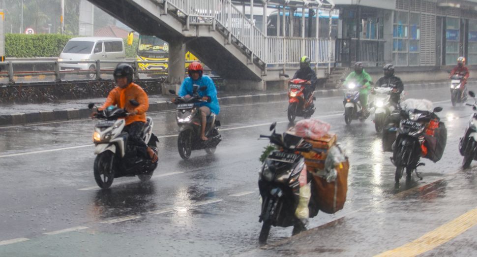 Pengendara motor nelintas saat hujan lebat di Jalan Gatot Subroto, Jakarta, Kamis (3/3/2023). [Suara.com/Alfian Winanto]