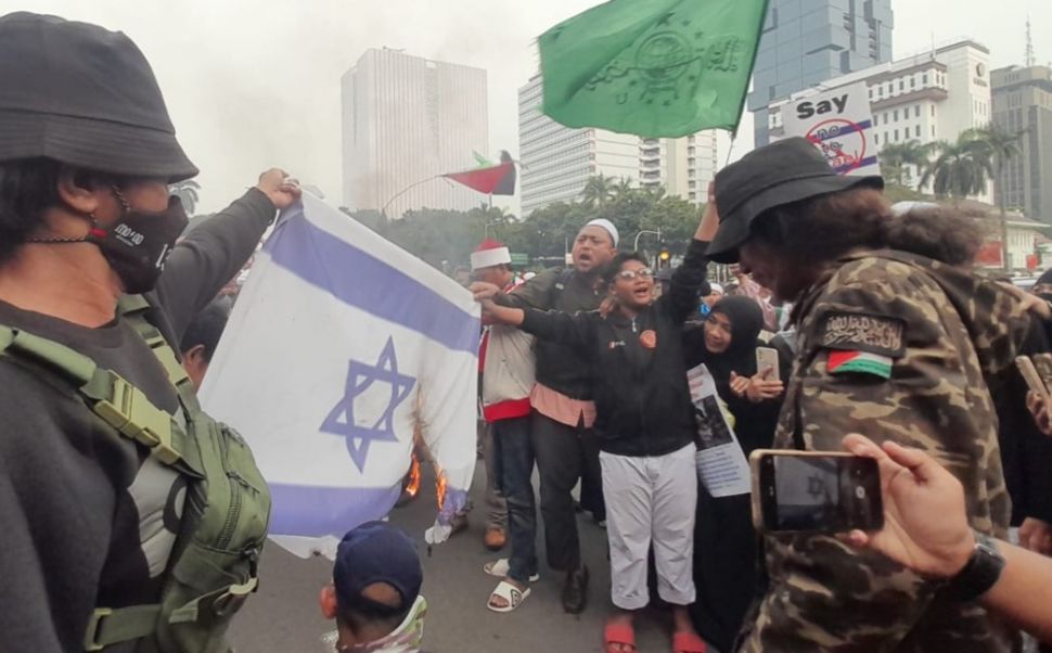 Aksi pembakaran bendera Israel oleh sejumlah peserta aksi demonstrasi dalam aksi menolak kedatangan Timnas U20 Israel dalam ajang Piala Dunia U20 di Indonesia. [Suara.com/Faqih]