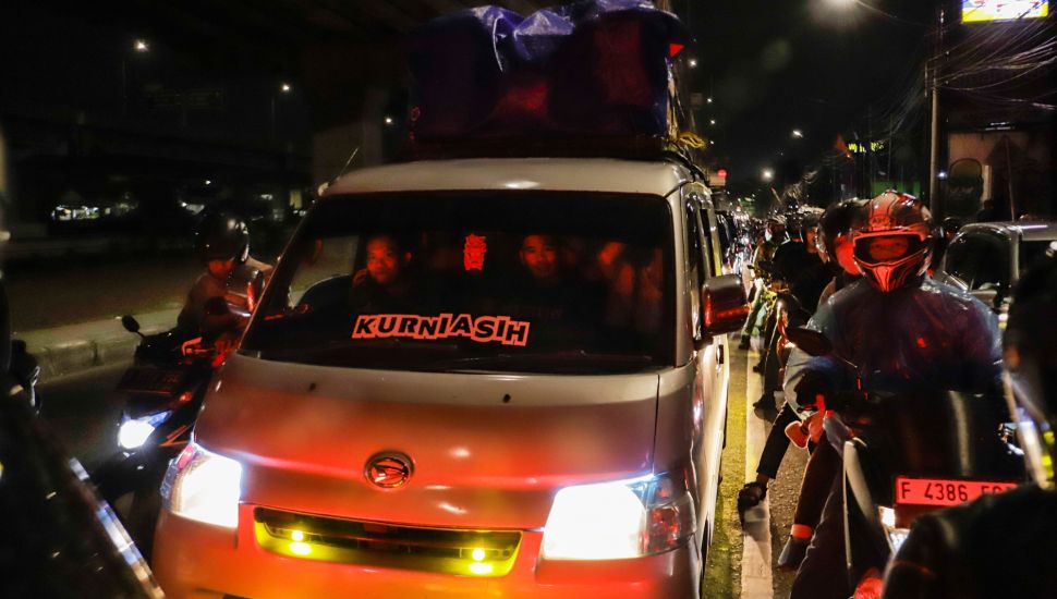 Pemudik melintas di Jalan Raya Kalimalang, Jakarta Timur, Rabu (19/4/2023) malam. [Suara.com/Alfian Winanto]