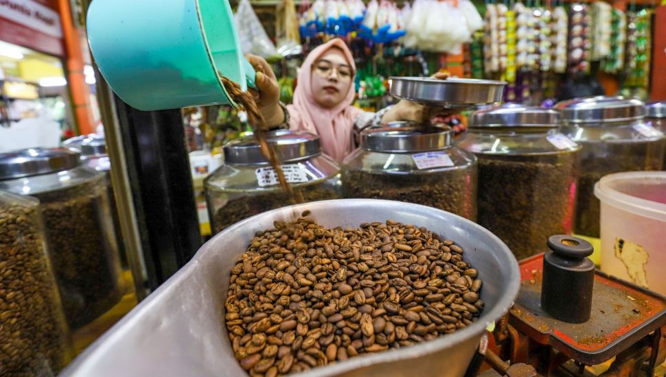 Pedagang menimbang kopi saat melayani pembeli di Dunia Kopi, Pasar Santa, Jakarta Selatan, Jumat (5/5/2023). [Suara.com/Alfian Winanto]
