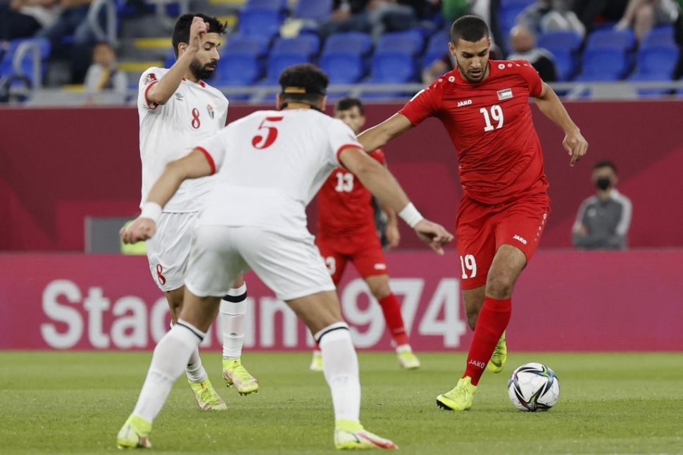 Penyerang Palestina Reebal Dahamshi (kanan) berebut bola dengan gelandang Jordan Noor al-Rawabdeh (kiri) dan bek Jordan Yazan al-Arab selama pertandingan sepak bola grup C Piala Arab FIFA 2021 antara Yordania dan Palestina di Stadion 974 di ibu kota Doha pada 7 Desember 2021.JACK GUEZ/AFP