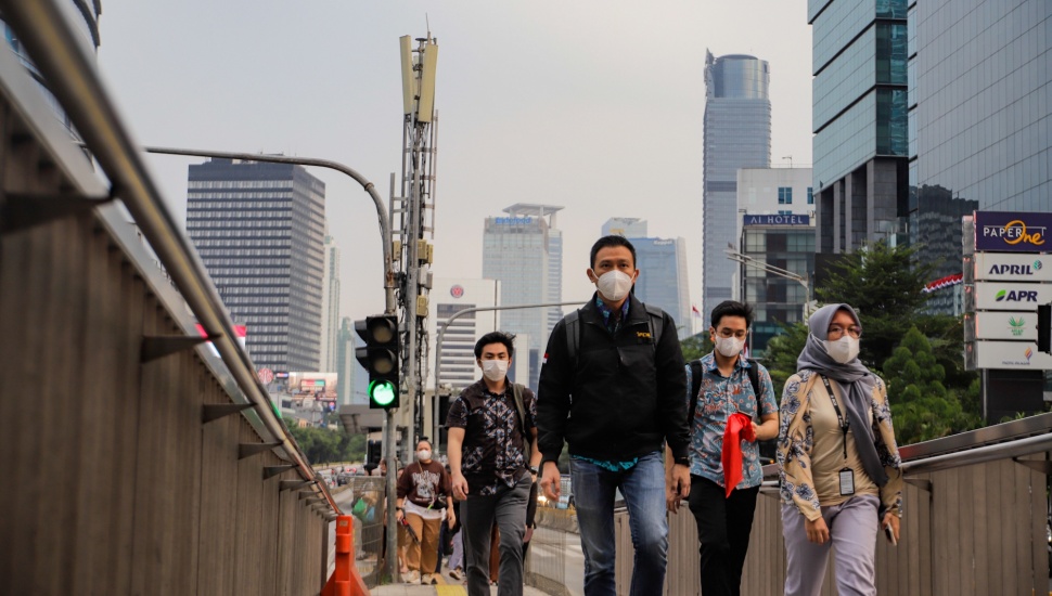 Masyarakat berjalan sambil menggunakan masker di Jalan MH Thamrin, Jakarta, Senin (21/8/2023). [Suara.com/Alfian Winanto]