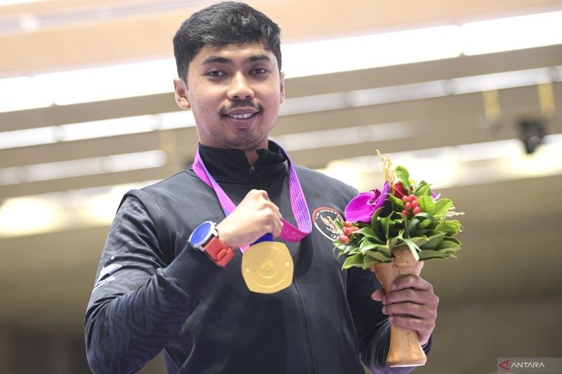 Petembak tunggal putra Indonesia Muhammad Sejahtera Dwi Putra berpose dengan medali emasnya usai upacara penghargaan pemenang final 10 meter running target Asian Games 2022 di Fuyang Yinhu Sports Centre, Hangzhou, China, Senin (25/9/2023). . ANTARA FOTO/M Risyal Hidayat/aww