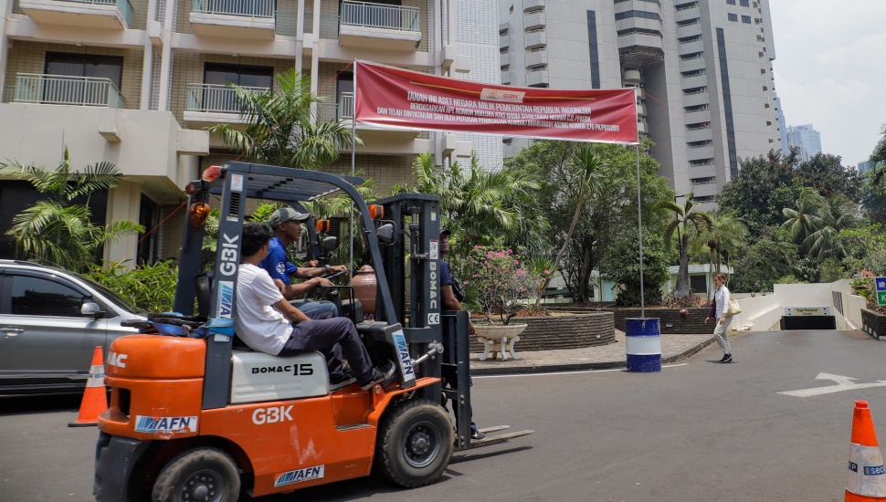 Petugas memasang spanduk peringatan di Hotel Sultan, Kompleks GBK, Jakarta, Rabu (4/10/2023). [Suara.com/Alfian Winanto]