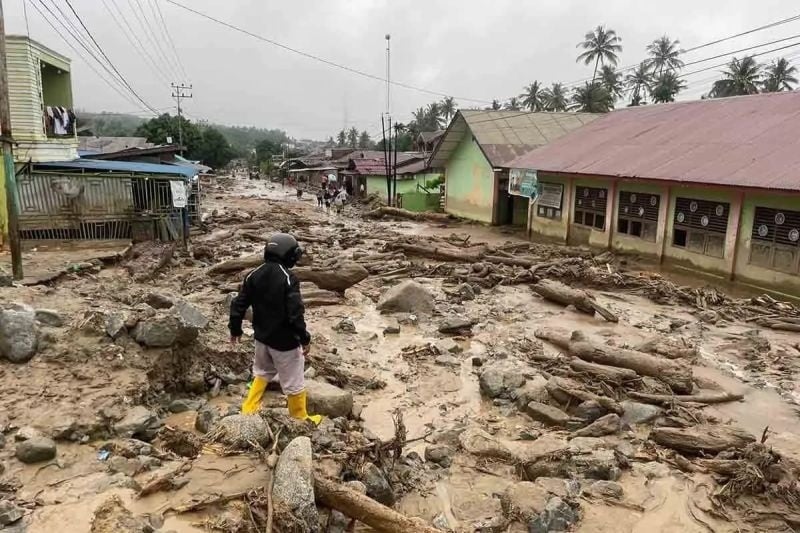 ilustrasi / Warga berjalan di dekat bangunan sekolah yang terdampak banjir bandang di Ladang Rimba, Kabupaten Aceh Selatan. (ANTARA/BPBD Aceh Selatan)