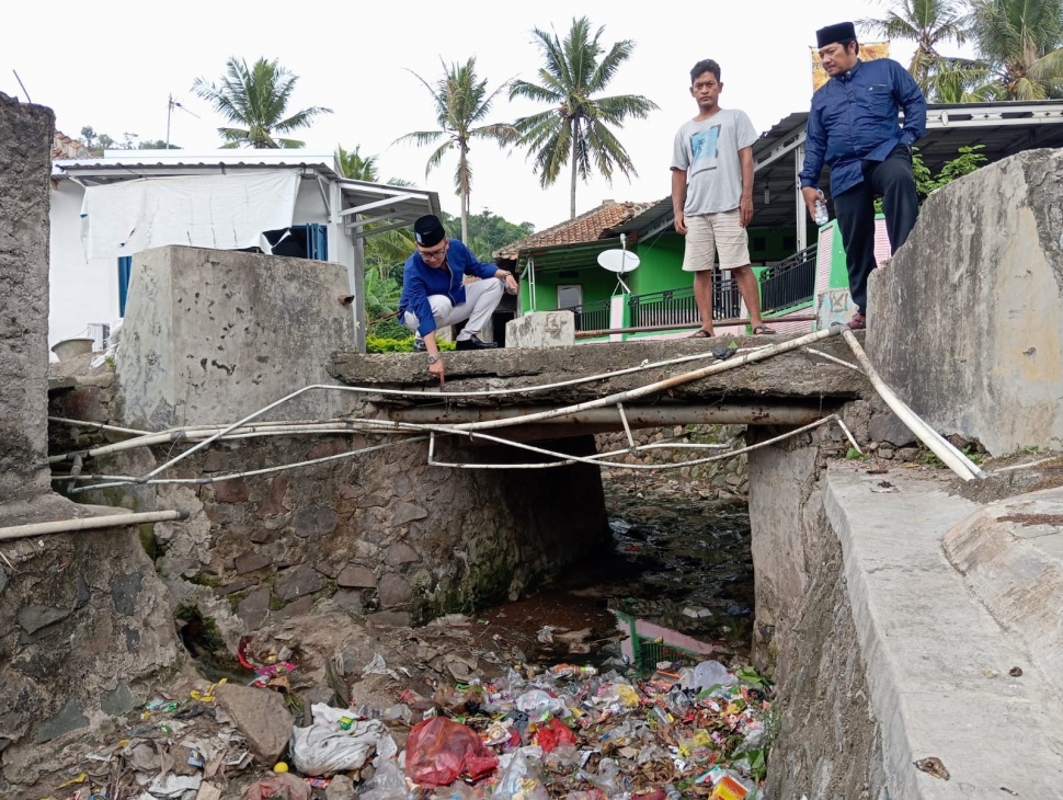 Caleg PAN DPRD Cilegon meninjau jembatan di Panesepan yang kondisinya sudah rapuh. [SuaraBanten.id/Hairul Alwan]