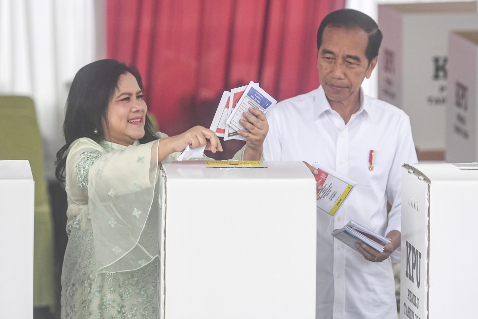 Presiden Joko Widodo (kanan) bersama Ibu Negara Iriana (kiri) memasukkan surat suara ke dalam kotak pada Pemilu 2024 di tempat pemungutan suara (TPS) 10 Kelurahan Gambir, kompleks Kantor Lembaga Administrasi Negara (LAN), Jakarta, Rabu (14/2/2024). [ANTARA FOTO/Muhammad Adimaja].