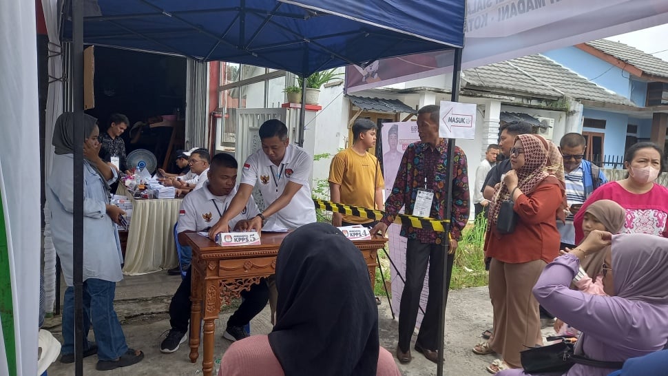 Petugas KPPS sedang melayani calon pemilih di salah satu TPS Pekanbaru, Rabu (14/2/2024). [Suara.com/Eko Faizin]