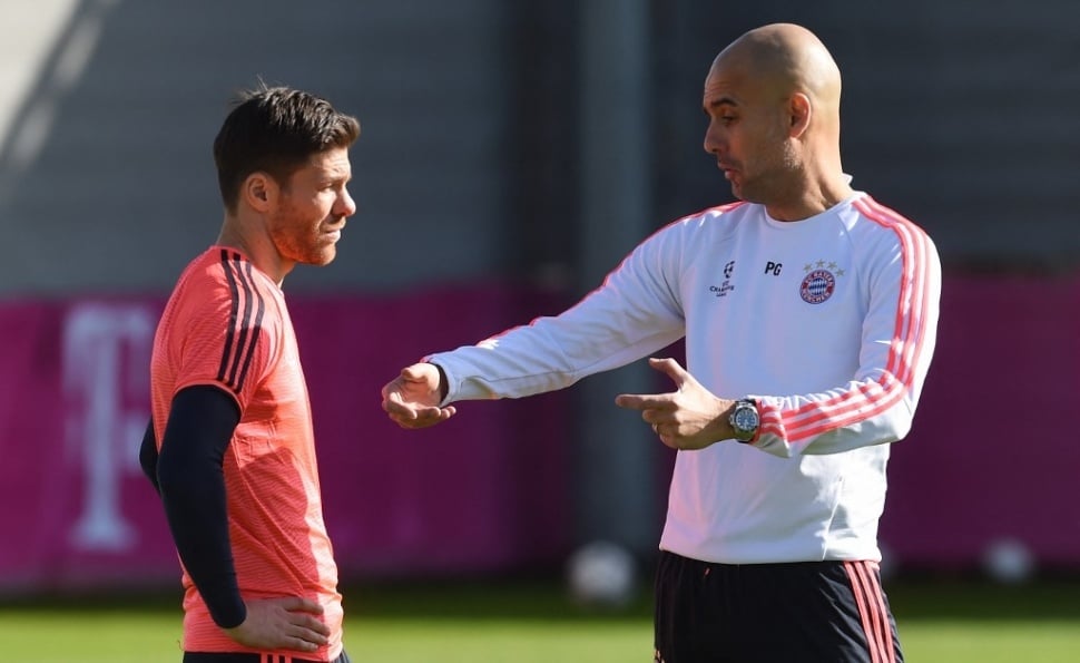 Pelatih kepala Bayern Munich asal Spanyol Pep Guardiola (kanan) berbicara dengan gelandang Spanyol Bayern Munich Xabi Alonso (kiri) selama sesi latihan tim terakhir satu hari sebelum babak 16 besar Liga Champions, pertandingan leg pertama antara Juventus Turin dan Bayern Munich di lapangan latihan di Munich, Jerman selatan, pada 22 Februari 2016.CHRISTOF STACHE / AFP