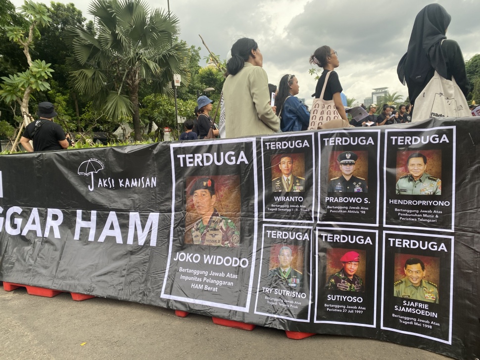 Spanduk pelanggar HAM yang dibawa peserta Aksi Kamisan di seberang Istana Negara Jakarta, Kamis (7/3/2024). [Suara.com/Faqih]