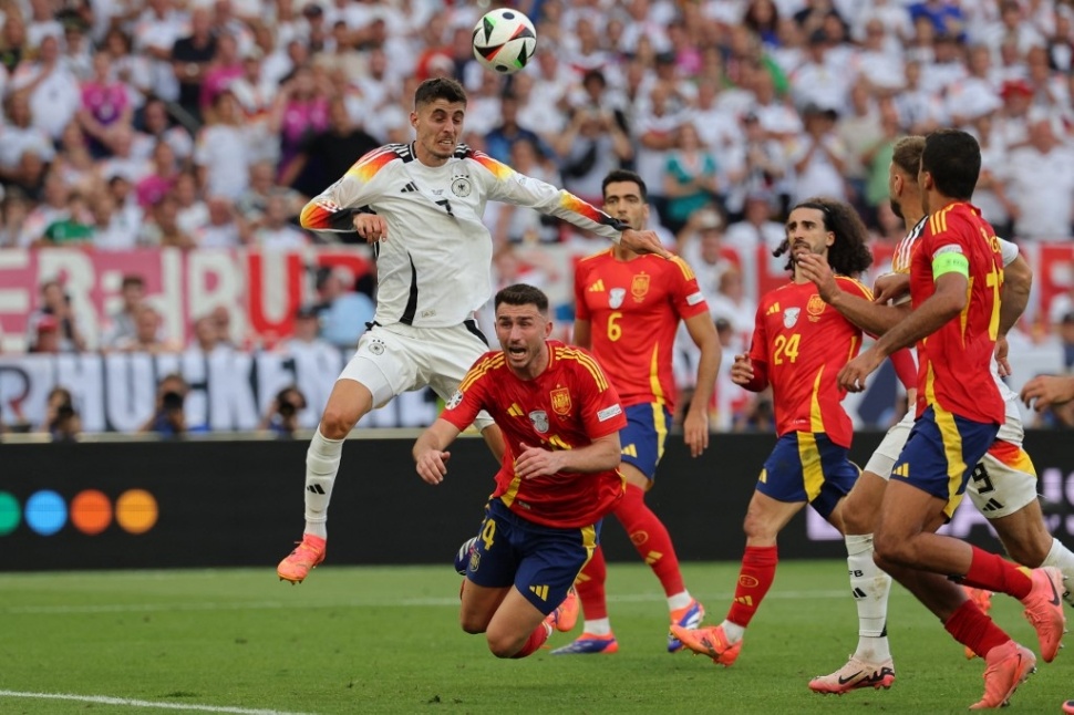 Penyerang Jerman Kai Havertz menyundul bola saat ia dihadang oleh bek Spanyol Aymeric Laporte selama pertandingan sepak bola perempat final UEFA Euro 2024 antara Spanyol dan Jerman di Stuttgart Arena di Stuttgart pada 5 Juli 2024.LLUIS GEN / AFP