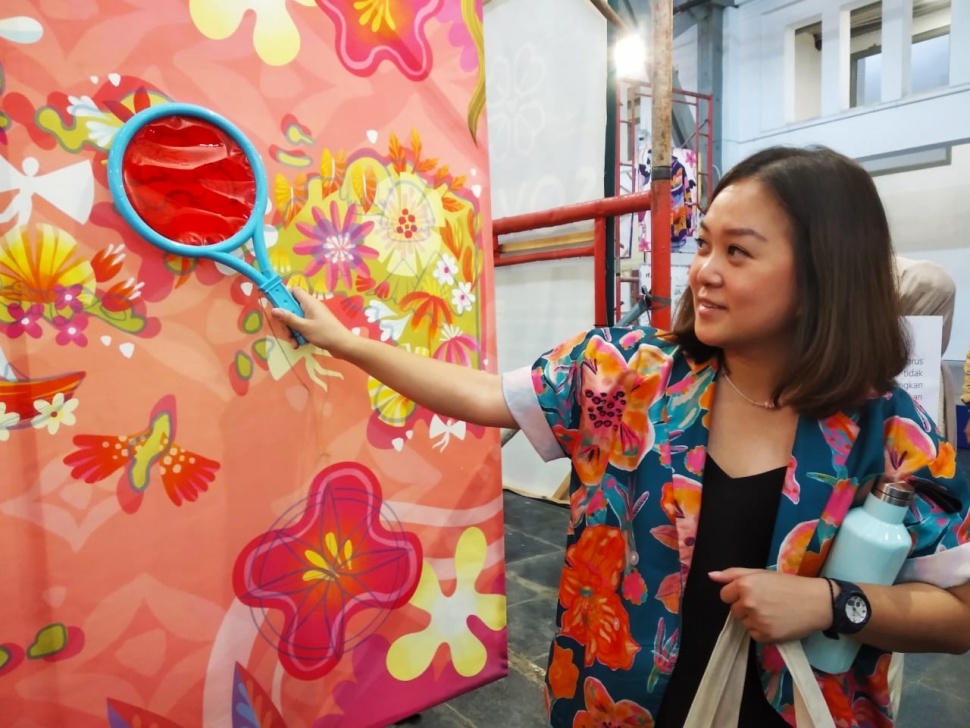 Pendiri Sovlo, Lidya Valensia saat menunjukkan salah satu karya seni ilustrator lokal yang dihadirkan di Pameran Seni Teras Inspirasi (TER4SI) di Posbloc, Jakarta Pusat, Jumat (12/7/2024). (Suara.com/Ririrn Indriani) 