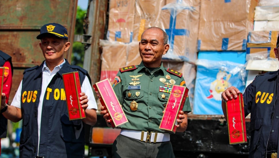 Petugas melakukan pemusnahan minuman keras ilegal hasil penindakan di Kantor Pusat Bea Cukai, Jakarta, Rabu (31/7/2024). [Suara.com/Alfian Winanto]