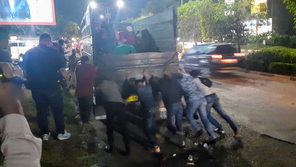 Warga membantu mendorong truk agar bisa menyalakan mesin karena mogok. Truk ini mengangkut pengungsi Rohingya di Banda Aceh,  pada Kamis (7/11/2024). [Suara.com/Habil]