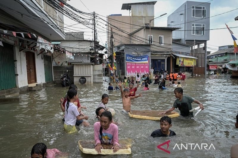 Arsip foto - Sejumlah anak bermain di tengah banjir rob di Muara Angke, Jakarta, Jumat (13/12/2024). ANTARA FOTO/Fauzan/foc/pri.