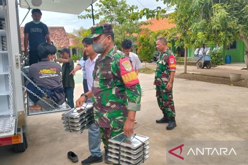 Prajurit TNI mengawal proses distribusi program Makan Bergizi Gratis di Kampung Sayuran, RT 05 RW 03, Desa Kertasari, Kecamatan Pebayuran, Kabupaten Bekasi, Rabu. ANTARA/Pradita Kurniawan Syah