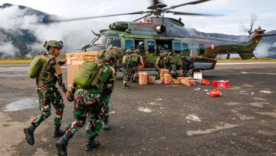 Prajurit TNI membawa logistik untuk program makan bergizi gratis perdana ke helikopter jenis Caracal milik TNI di Distrik Sugapa, Kabupaten Intan Jaya, Papua Tengah, Senin (20/1/2025). [ANTARA FOTO/Martinus Eguay/app/tom]