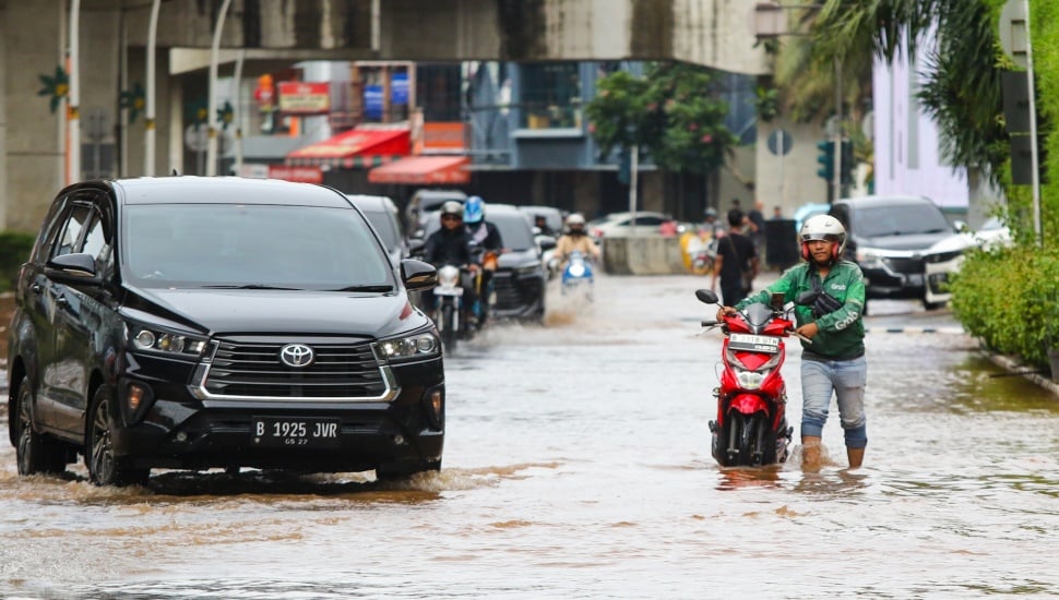 Pengendara melintasi banjir di Jalan Boulevard Raya, Kelapa Gading, Jakarta, Rabu (29/1/2025). [Suara.com/Alfian Winanto]