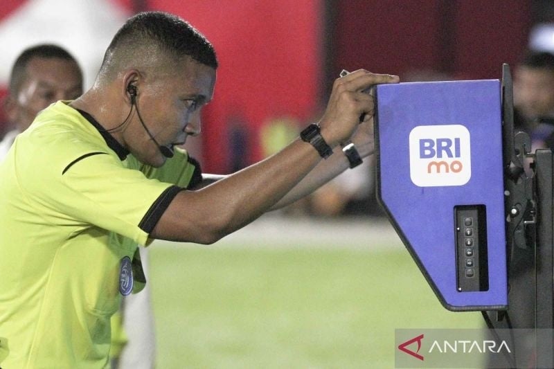 Wasit Agung Setiayawan (kanan) melihat Video Assistant Referee (VAR) setelah pesepak bola Malut United dijatuhkan penjaga gawang Borneo FC Nadeo Winata pada laga lanjutan BRI Liga 1 di Stadion Gelora Kie Raha Ternate, Maluku Utara, Senin (10/2/2025). Tuan rumah Malut United mengalahkan tamunya Borneo FC Samarinda dengan skor 3-0. ANTARA FOTO/Andri Saputra/YU