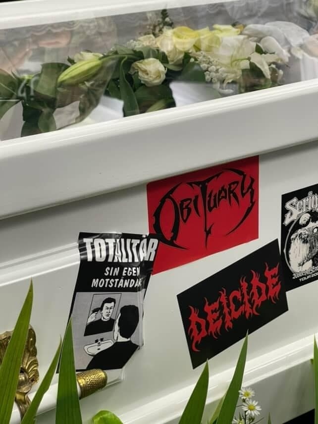 Peti jenazah Ricky Siahaan ditempel stiker-stiker band kesukannya [Suara.com/Rena Pangesti]