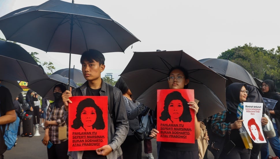 Aktivis Jaringan Solidaritas Korban untuk Keadilan membawa poster Marsinah saat mengikuti aksi Kamisan ke-860 di depan Istana Merdeka, Jakarta, Kamis (8/5/2025). [Suara.com/Alfian Winanto]