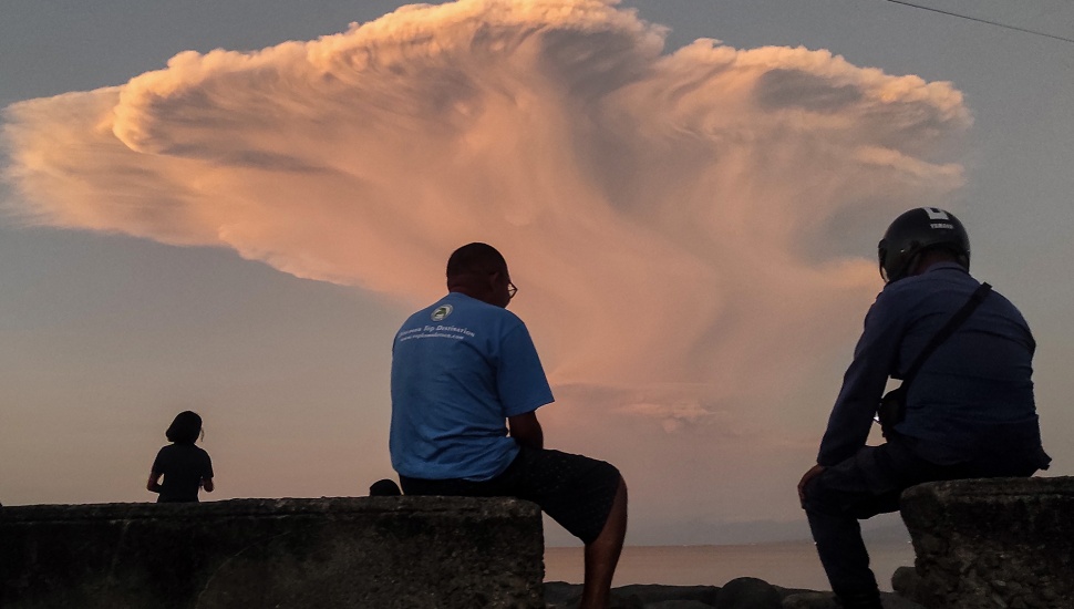 Warga melihat erupsi Gunung Lewotobi Laki-laki dari Pantai Wairotang, Kabupaten Sikka, Nusa Tenggara Timur, Selasa (17/6/2025). [ANTARA FOTO/Arnoldine Shanon/sgd/foc]