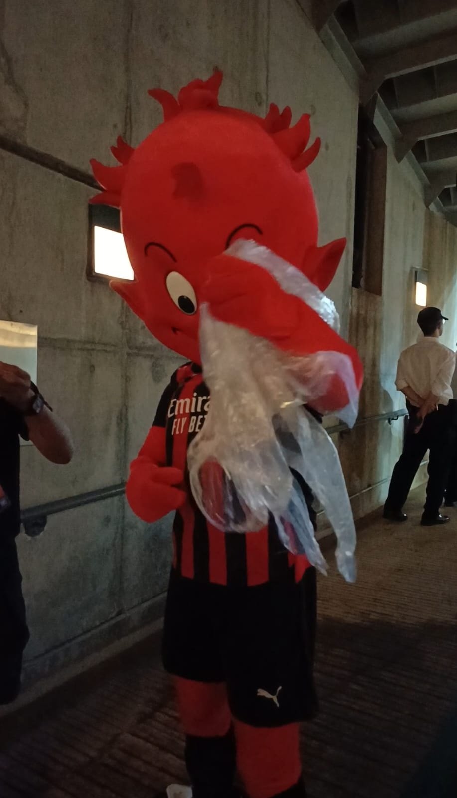 Peristiwa lucu terjadi di sela-sela latihan terbuka AC Milan di Hong Kong Stadium, Hong Kong, Jumat (25/7/2025) malam waktu setempat. Maskot Rossoneri terlihat kesulitan memakai jas hujan.  [Suara.com/Arief Apriadi]