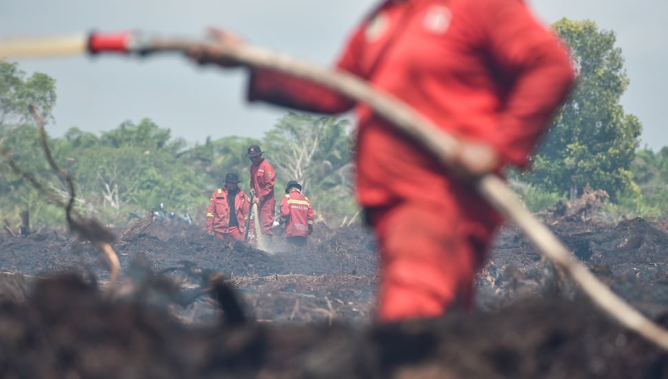 Petugas Manggala Agni Daops Kota Jambi memadamkan api kebakaran hutan dan lahan (karhutla) di lahan gambut Desa Gambut Jaya, Muaro Jambi, Jambi, Rabu (30/7/2025). [ANTARA FOTO/Wahdi Septiawan/foc]