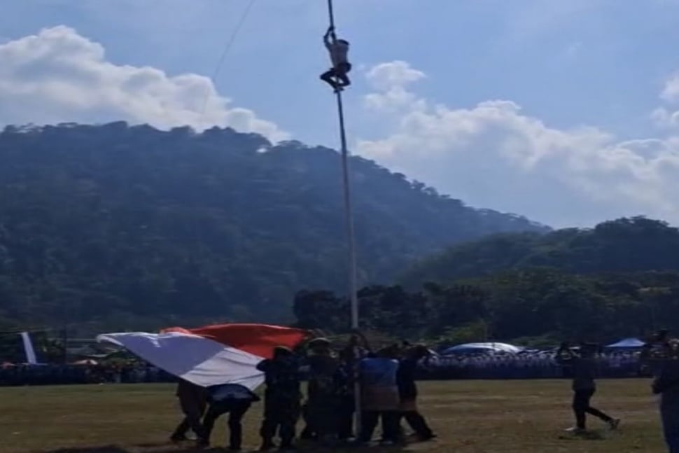 bocah sd panjat tiang bendera di Way Muli, Lampung Selatan, saat upacara pengibaran bendera HUT ke-80 RI. [ANTARA]