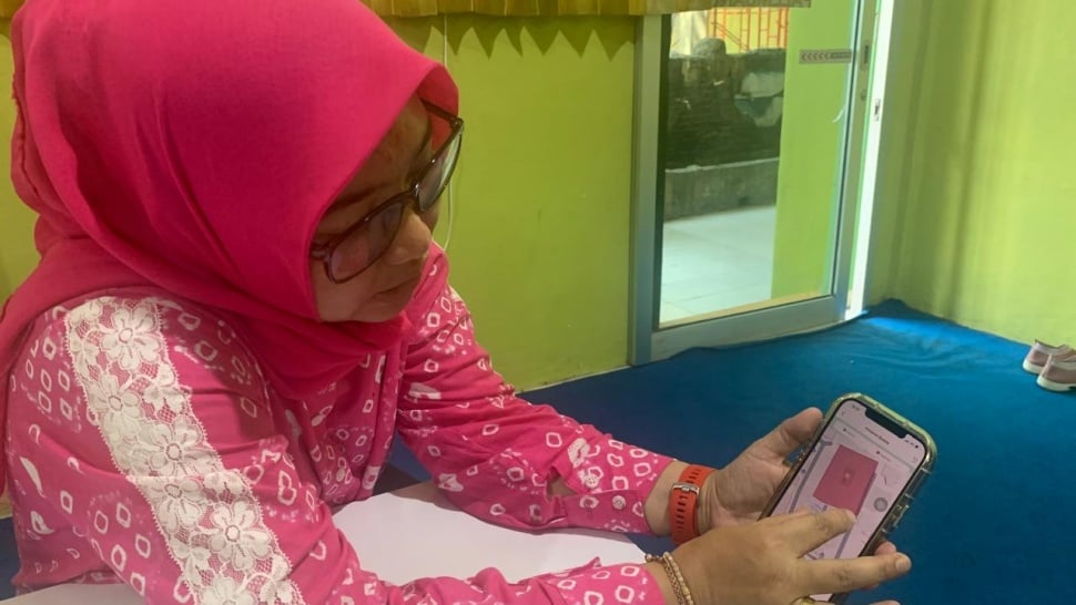 Guru yang memperlihatkan aplikasi skul.id