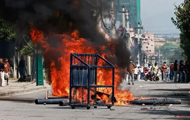 Para demonstran melakukan aksi pembakaran di depan gedung parlemen Nepal. (Foto: AFP via Getty Images/BBC Indonesia)