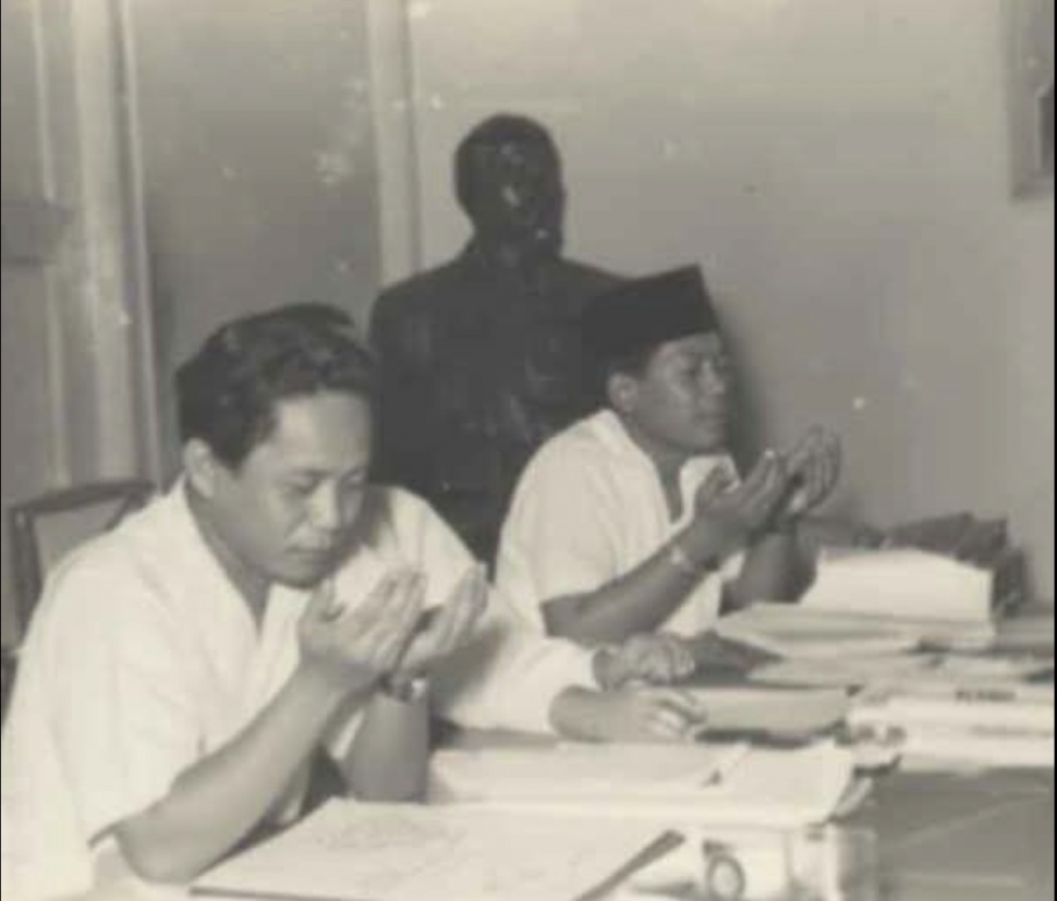 Ketua CC PKI DN Aidit (kiri) dan Wakil Ketua PKI MH Lukman (kanan) sedang berdoa dalam sebuah rapat di Kantor CC PKI, Kramat Raya 81. [dokumentasi/Oey Hay Djoen]