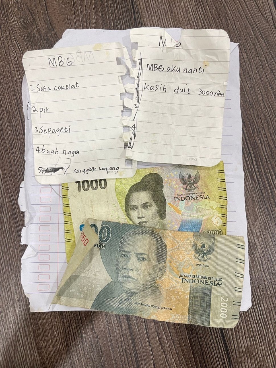 Temuan secarik kertas bertuliskan pesanan menu yang ditulis seorang siswa dan uang Rp3.000 oleh petugas SPPG Margomulyo Seyegan. [Dok: SPPG Margomulyo Seyegan]