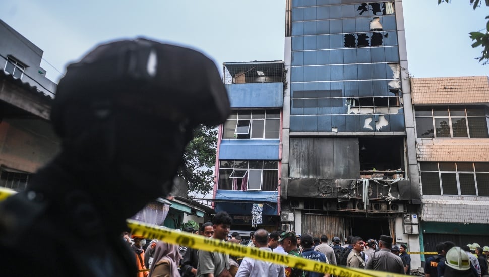 Petugas kepolisian berjaga di dekat gedung Terra Drone yang terbakar di jalan Letjen Soeprapto, Cempaka Baru, Kemayoran, Jakarta Pusat, Selasa (9/12/2025). [ANTARA FOTO/Hafidz Mubarak A/foc]